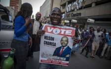 FILE: MDC supporters hold placard with the face of party leader Nelson Chamisa outside the party's headquarters in Harare. Picture: EWN