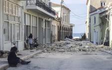 People walk past a destroyed house after an earthquake in the island of Samos, Greece, on 30 October 2020. Picture: AFP.