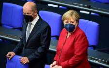 FILE: In this file photo taken on August 25, 2021 German Finance Minister, Vice-Chancellor and the Social Democratic SPD party's candidate for Chancellor Olaf Scholz stands next to German Chancellor Angela Merkel ahead a plenary session at the German lower house of parliament Bundestag in Berlin. Tobias Schwarz / AFP