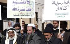 Palestinian men, holding placards bearing slogans praising Islam's Prophet Mohammed, take part in a demonstration in protest against a recent cartoon of the prophet that was published by the French satirical magazine Charlie Hebdo. Picture: AFP. 