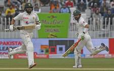 Pakistan's Azhar Ali (L) and teammate Mohammad Rizwan run between the wickets during the second day of play of the first Test cricket match between Pakistan and Australia at the Rawalpindi Cricket Stadium in Rawalpindi on March 5, 2022. Picture: Aamir Qureshi / AFP.