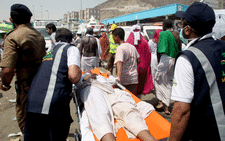 Saudi emergency personnel transport a Hajj pilgim on a stretcher at the site where at least 717 were killed and hundreds wounded in a stampede in Mina, near the holy city of Mecca, at the annual hajj in Saudi Arabia on 24 September, 2015. Picture: AFP.