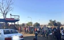 A large crowd of onlookers are gathered at a shopping complex in White City, Soweto, where some of the stores have been looted. Picture: Katleho Sekhotho/EWN