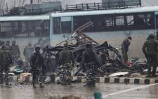Indian security forces inspect the remains of a vehicle following an attack on a paramilitary Central Reserve Police Force (CRPF) convoy that killed at least 16 troopers and injured several others in Kashmir on 14 February 2019. Picture: AFP.