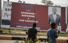 People walk past eSwatini parliamentary election billboards on 19 September, 2018 in Lobamba. Picture: AFP