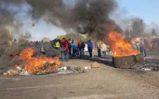 Ennerdale residents gather near burning tyres and rocks during a protest on 5 October 2018 over what they say is the neglect of coloured communities. Picture: Louise McAuliffe/EWN