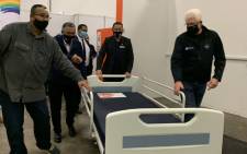 FILE: Western Cape Premier Alan Winde (right) and provincial head of Health Dr Keith Cloete (centre) help officials wheel out a hospital bed as the CTICC's Hospital of Hope is officially decommissioned on 21 August 2020. Picture: Kaylynn Palm/Eyewitness News.