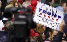 A supporter of President Donald Trump holds up a sign reading "CNN sucks" during a campaign rally for Republican Senate candidate Mike Braun and attended by President Donald Trump at the County War Memorial Coliseum 5 November, 2018 in Fort Wayne, Indiana. Picture: AFP
