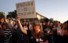 Mourners stand during a candlelight vigil for the victims of Marjory Stoneman Douglas High School shooting in Parkland, Florida, on 15 February 2018. Picture: AFP.