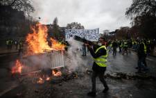 Protesters build a barricade during a protest of yellow vests against rising oil prices and living costs, on 1 December, 2018 in Paris. Picture: AFP