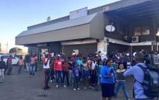 A group of White City residents gathers near a news crew after some of the stores have been looted and two people killed. Picture: Katleho Sekhotho/EWN.