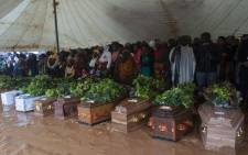 Mourners stand behind coffins of their relatives during a mass funeral for Cyclone Freddy mudslide victims at Chilobwe township’s Naotcha Primary school camp in Blantyre, Malawi, on March 15, 2023.  Picture: Amos Gumulira / AFP