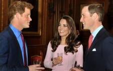 Britain's Prince William (R) talks with his wife Catherine, Duchess of Cambridge (C) and his brother Prince Harry (L). Picture: AFP.