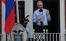 Julian Assange addresses the press and his supporters from the balcony of the Ecuadorian Embassy in London. Picture: AFP.