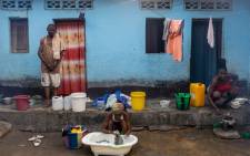 A woman washes clothes with water drawn from a well in Selembao, a poor neighbourhood with very little water or electricity provision on the outskirts of Kinshasa, on July 14, 2023. The trek for water is a daily burden for people living in the neighbourhood of Selembao. Picture: AFP