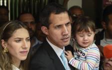 Opposition leader and self-proclaimed "acting president" Juan Guaido (C) addresses the press as he holds his daughter Miranda, next to his wife Fabiana Rosales (L), outside his home in Santa Fe, Caracas on 31 January 2019. Picture: AFP