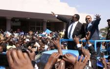 Malawi's newly elected President, Professor Peter Mutharika (2nd R), a young brother of the former late President Bingu wa Mutharika, and his Deputy Saulos Chilima (R) greet supporters after taking an oath of office at the High Court on 31 May 2014, in Blantyre, Malawi. Picture: AFP.