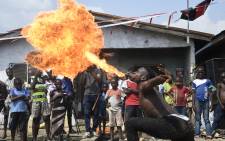 A dancer spits fire during a slum party at Oworonshoki district of Lagos on 27 November 2021. Picture: AFP