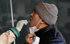 A health worker takes a swab sample from a man to be tested for the COVID-19 coronavirus at a hospital in Beijing on 26 December 2022. Picture: Noel CELIS/AFP