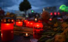 FILE: PoliFlowers and candles lie near the Olympia Einkaufszentrum shopping centre on 24 July 2016 in Munich, southern Germany, where an 18-year-old German-Iranian student run amok. Picture: Christof Stache/AFP.