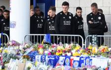 (L-R) Leicester City's English defender Danny Simpson, Leicester City's English-born Jamaican defender Wes Morgan, Leicester City's English midfielder James Maddison, Leicester City's English defender Harry Maguire, Leicester City's English midfielder Matty James and goalkeeping coach Mike Stowell look at the floral tributes left to the victims of the helicopter crash which killed Leicester City's Thai chairman Vichai Srivaddhanaprabha, outside Leicester City Football Club's King Power Stadium in Leicester, eastern England, on 29 October 2018. Picture: AFP.