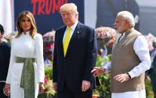 India's Prime Minister Narendra Modi (R) speaks with US President Donald Trump (C) and First Lady Melania Trump (L) upon their arrival at Sardar Vallabhbhai Patel International Airport in Ahmedabad on 24 February 2020. Picture: AFP