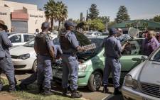 Police inspect a suspected vehicle of licensing fraud at the Rand West City Local Municipality. The owner had numerous registration papers and license plates in the vehicle, and the license disk did not match the registration plates. Picture: Thomas Holder/EWN.