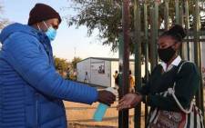 FILE: A teacher sanitises the hands of a pupil returning to school in 2020. Picture: Gauteng Provincial Government.