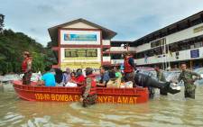 Rescue officials evacuate people in a boat in Shah Alam, Selangor on 20 December 2021, as Malaysia faces some of its worst floods for years. Picture: Arif KARTONO/AFP