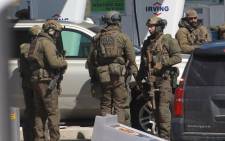 FILE: Members of the Royal Canadian Mounted Police (RCMP) tactical unit confer after the suspect in a deadly shooting rampage was neutralised at the Big Stop near Elmsdale, Nova Scotia, Canada, on 19 April 2020. Picture: AFP.