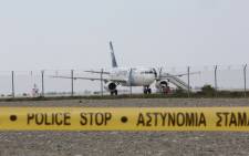 Cypriot security forces cordon off the area around Larnaca airport where an EgyptAir Airbus A-320 is seen on the tarmac after being hijacked and diverted to Cyprus on 29 March 2016. Picture: AFP.