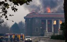 Firefighters try, in vain, to extinguish a fire in the Jagger Library, at the University of Cape Town, after a forest fire came down the foothills of Table Mountain, setting university buildings alight in Cape Town, on 18 April 2021. Picture: Rodger Bosch/AFP
