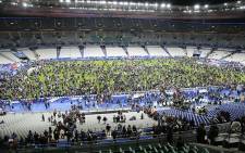 Spectators wait on the pitch of the Stade de France stadium in Seine-Saint-Denis, Paris' suburb on November 13, 2015 after a series of gun attacks occurred across Paris as well as explosions outside the national stadium where France was hosting Germany. Picture:AFP