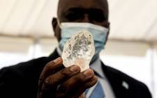 Botswana President Mokgweetsi Masisi (R) holds a gem diamond in Gaborone, Botswana, on 16 June 2021. Botswanan diamond firm Debswana said on 16 June 2021 it had unearthed a 1,098-carat stone that it described as the third largest of its kind in the world.
The stone, found on 1 June 2021 was shown to President Mokgweetsi Masisi in the capital Gaborone. Picture: AFP
