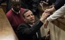 FILE: Oscar Pistorius holding the hand of a relative as he leaves the High Court in Pretoria, on July 6, 2016 after being sentenced to six years in jail for murdering his girlfriend Reeva Steenkamp. Picture: AFP