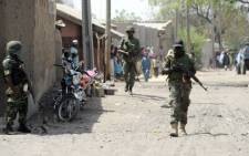 FILE: A file photo taken on 30 April, 2013 shows soldiers walking in the street in the remote northeast town of Baga, Borno State. Picture: AFP. 