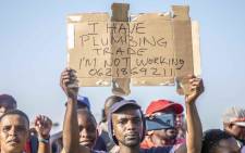 Cosatu supporter holding up a poster at the federation's May Day rally at Sugar Ray Xulu stadium in Clermont, Durban. Picture: Abigail Javier/EWN