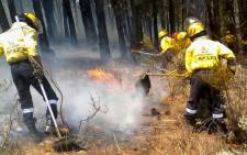 FILE: This file photo shows Working on Fire firefighters battle a blaze in the Helderberg in the Western Cape. Picture: @wo_fire/Twitter