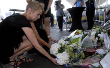People lay flowers and light candles in front of the Schiphol airport on July 18, 2014, a day after a Malaysian Airlines flight MH17 carrying 298 people from Amsterdam to Kuala Lumpur crashed in eastern Ukraine. Picture: AFP.