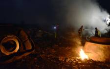 Firefighters among the wreckages of the Malaysian Airliner carrying 295 people from Amsterdam to Kuala Lumpur after it crashed, near the town of Shaktarsk, in rebel-held east Ukraine. Picture: AFP.