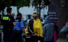 FILE: Police eject anti-vaxxers who demonstrate outside the Arena Treptow vaccination centre, where people arrive to receive a vaccination against the coronavirus during a long night of vaccinations with music, in Berlin on August 9, 2021, during the ongoing pandemic. Picture: John Macdougall / AFP.