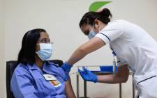 FILE: A handout picture taken by the Government of Dubai Media Office on 23 December 2020, shows a health worker administering a dose of the coronavirus vaccine to a nurse at a medical centre in the Dubai Emirate. Picture: AFP