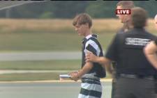 In this screen grab taken from WBTV News, shooting suspect Dylann Roof (L) is escorted by police at the Shelby-Cleveland County Regional Airport for extradition back to Charleston, South Carolina in Shelby, North Carolina on 18 June, 2015. Picture: AFP.