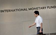 FILE: A man walks past the headquarters of the International Monetary Fund (IMF) on 30 June 2015 in Washington, DC. Picture: AFP.