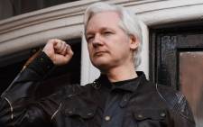 In this file photo taken on 19 May 2017, Wikileaks founder Julian Assange raises his fist prior to addressing the media on the balcony of the Embassy of Ecuador in London. Picture: AFP