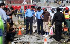 FILE: Pakistani security officials inspect the site of a bomb explosion at a fruit and vegetable market in Islamabad on 9 April 2014. Picture: AFP.