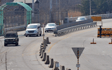 A South Korean military vehicle leads cars arriving from the Kaesong joint industrial park in North Korea, at a military check point of the inter-Korean transit office in Paju on April 3, 2013 after being refused access to the Seoul-funded Kaesong complex. Picture: AFP/JUNG YEON-JE