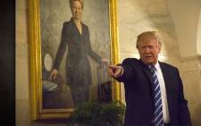 Hillary Clinton is looking over President Trump's shoulder...literally.  Picture: CNN