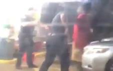 A screengrab from a video on CNN's YouTube channel shows two police officers approaching Alton Sterling, right in red T-shirt, before the fatal shooting. Picture: CNN via YouTube.