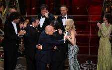 Winner for Best Picture 'Birdman', Alejandro G. Iñárritu (obscured) hugs cast members as Naomi Watts (C-R) and Emma Stone (R) look on at the 87th Oscars 22 February, 2015 in Hollywood, California. Picture: AFP.